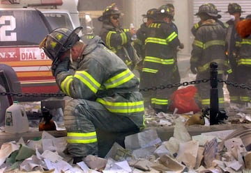 El bombero Gerard McGibbon, de la unidad 283 de Brownsville, Brooklyn, reza después de que los edificios del World Trade Center se derrumbaran.