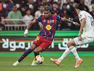 Barcelona's Spanish forward #10 Lamine Yamal (L) and Real Madrid's Spanish defender #18 Alvaro Carreras fight for the ball during the Spanish Super Cup final football match between FC Barcelona and Real Madrid at the King Abdullah Stadium�in Jeddah on January 11, 2026. (Photo by Fadel SENNA / AFP)