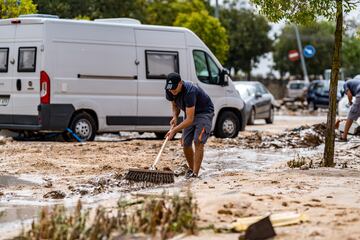 Una persona trata de evitar que el agua se acumule en una de las zonas afectadas por las inundaciones provocadas por la DANA en El Álamo, Madrid.