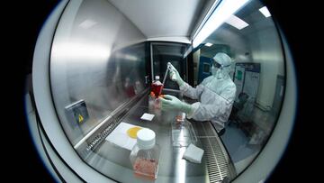 (FILES) In this file photo taken on July 10, 2020 a lab technician wearing Personal Protective Equipment (PPE) performs tests under a hood, using reagent bottles at a French pharmaceutical company Sanofi's laboratory in Val-de-Reuil. (Photo by JOEL SAGET / AFP)