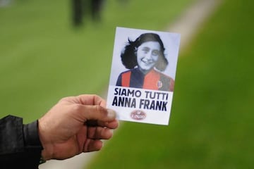 A person shows an image of holocaust victim Anne Frank with reading "We are all Anne Frank"