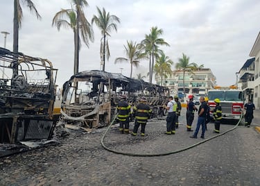 Bomberos trabajan en el lugar donde miembros del crimen organizado incendiaron autobuses. 