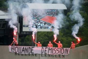 Varios manifestantes con bengalas encendidas antes del comienzo del partido de la final individual masculina entre Rafael Nadal y David Ferrer en Roland Garros