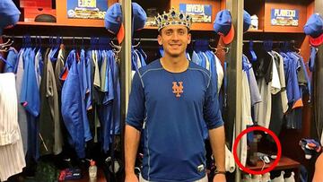 El héroe del partido T. J. Rivera posa con la corona como mejor jugador y con el vibrador en la taquilla de su compañero Kevin Plawecki.