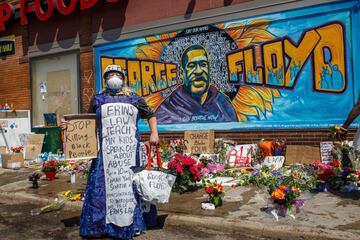 A protester stands near a memorial following a day of demonstration in a call for justice for George Floyd, who died while in custody of the Minneapolis police, on May 30, 2020 in Minneapolis, Minnesota. - Demonstrations are being held across the US after George Floyd died in police custody on May 25. (Photo by Kerem Yucel / AFP)