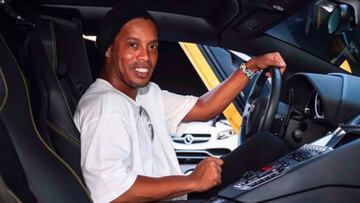 Ronaldinho sonriendo al volante de un coche.