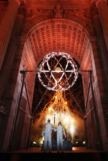 Los portadores de la antorcha, Deborah Compagnoni y Alberto Tomba, encienden el pebetero olímpico en la ceremonia inaugural de los Juegos Olímpicos de Invierno.