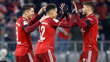 Bayern Munich's Polish forward Robert Lewandowski (L) celebrates scoring the 4-0 goal with Bayern Munich's German midfielder Jamal Musiala (C) and Bayern Munich's French defender Lucas Hernandez during the German first division Bundesliga f