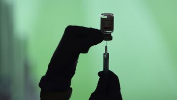 Un profesional sanitaria sostiene una jeringuilla y un vial con la vacuna del Covid-19