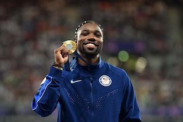 Gold medallist US' Noah Lyles celebrates on the podium during the victory ceremony for the men's 100m athletics event during the Paris 2024 Olympic Games at Stade de France in Saint-Denis, north of Paris, on August 5, 2024. (Photo by MARTIN BERNETTI / AFP)