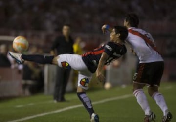 El jugador de San Lorenzo Pablo Barrientos (i) disputa el balón con Leonardo Pisculichi de River Plate en el partido de ida de la final de la Recopa Sudamericana.