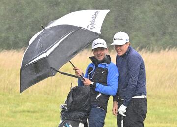 El finlandés Sami Valimaki y su caddie se refugian de la lluvia bajo un paraguas durante la tercera jornada del Abierto de Gales de golf, perteneciente al Circuito Europeo y que tiene lugar en el Celtic Manor Resort de la localidad galesa de Newport. El juego tuvo que interrumpirse momentáneamente durante la disputa del cuarto hoyo.