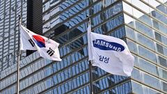 A South Korean naitonal flag (L) and a Samsung flag (R) flutter outside the company's Seocho building in Seoul on October 7, 2022, after Samsung Electronics expected operating profits in the third quarter to fall 31.7 percent. (Photo by Jung Yeon-je / AFP) (Photo by JUNG YEON-JE/AFP via Getty Images)