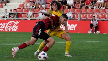 Tachi protege el balón ante la presencia de Álex Calvo.