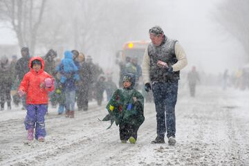 Ella, Cooper y Colin Reilly marchan a través de la nieve durante el desfile anual de vacaciones de Hamburgo el 30 de noviembre de 2024 en Hamburgo, Nueva York.