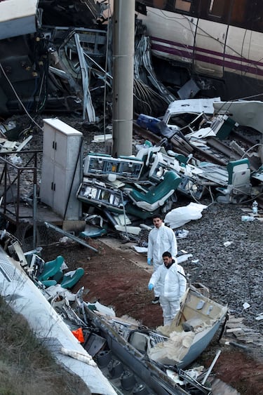 Bomberos y miembros de la Guardia Civil trabajan junto a uno de los trenes implicados en el accidente.