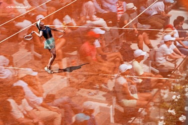 A veces un simple reflejo en un crtistal puede lograr el más original de los efectos en una fotografía. En la que ilustra este texto se ve a la estadounidense Danielle Collins en el momento de servir a la polaca Iga Swiatek durante su partido en el Masters 1.000 de Roma. Parece que los aficionados estuvieran sentados sobre la propia arcilla del Foro Itálico romano.