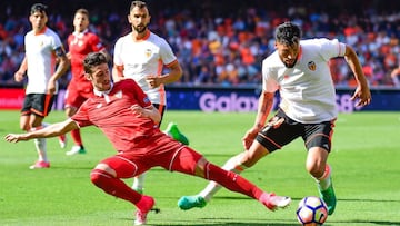 Sevilla's defender Sergio Escudero (L) vies with Valencia's Argentinian defender Ezequiel Garay during the Spanish league football match Valencia CF vs Sevilla FC at the Mestalla stadium in Valencia on April 16, 2017. / AFP PHOTO / JOSE JORDAN