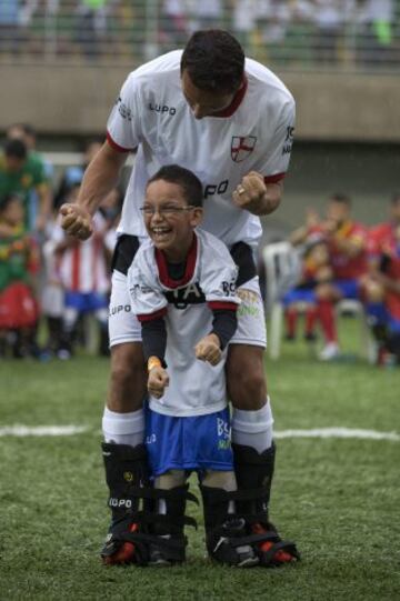 El futbolista brasileño Nene y el niño Rikellmy celebran un gol durante un evento con niños discapacitados, en Praia Grande (Brasil)