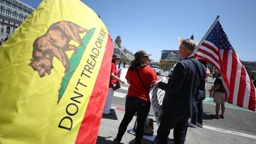 SAN FRANCISCO, CALIFORNIA - MAY 01: A demonstrator holds a custom &#039;Don&#039;t Tread On Me&#039; flag as she protests California Gov. Gavin Newsom&#039;s continued statewide shelter in place order outside of San Francisco City Hall on May 01, 2020 in 