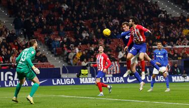 Juan Latasa intenta rematar un centro lateral ante la oposición de Mario Hermoso. Jan Oblak atento a la jugada.