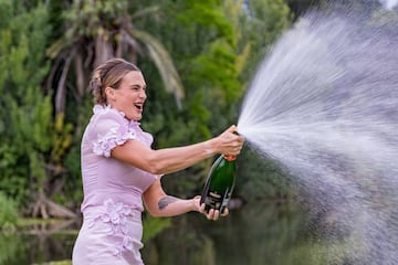 Aryna Sabalenka abriendo una botella de champán agitada durante la sesión de fotos como campeona del Abierto de Australia en los Jardines Reales de Melbourne.