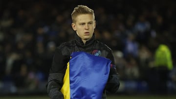 Oleksandr Zinchenko, jugador del Manchester City, recoge una bandera de Ucrania antes de un partido.