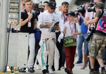 Lewis Hamilton firma autógrafos a los fans.