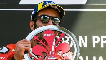 Italy&#039;s Danilo Petrucci holds his trophy as he celebrates on the podium after winning the Italian Moto GP Grand Prix at the Mugello race track on June 2, 2019 in Scarperia e San Piero. (Photo by Tiziana FABI / AFP)