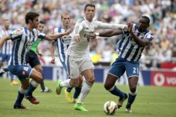 El delantero portugués del Real Madrid Cristiano Ronaldo (c) pelea un balón con los jugadores del Deportivo Juan Domínguez (i) y Modibo Diakité.