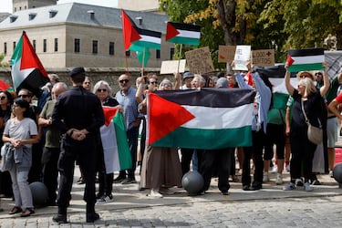 Agentes de la Guardia Civil observan a manifestantes pro-palestinos con banderas y pancartas palestinas durante la 20.ª etapa de la Vuelta a España 2025.