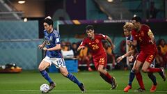 Japan's midfielder #15 Daichi Kamada (L) is chased by Spain's midfielder #26 Pedri (C) during the Qatar 2022 World Cup Group E football match between Japan and Spain at the Khalifa International Stadium in Doha on December 1, 2022. (Photo by Anne-Christine POUJOULAT / AFP)