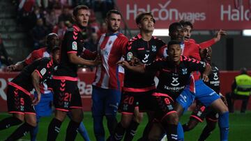 Jugadores forcejean antes del saque de un córner.
