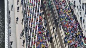  Los participantes en la marat&oacute;n de Rotterdam pasan por el Puente Erasmo, en el centro de la ciudad. 
