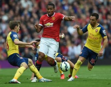 Antonio Valencia intenta pasar ante Nacho Monreal y Santi Cazorla.