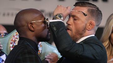 MMA fighter Connor Mcgregor (R) removes his glasses to glare at boxer Floyd Mayweather Jr. as they face-off during a media press conference August 23, 2017 at the MGM Grand in Las Vegas, Nevada. 
 Mayweather, the 40-year-old undefeated former welterweight boxing champion, has been lured out of retirement to face McGregor, a star of mixed martial arts&#039; Ultimate Fighting Championship. The two men meet in a 12-round contest under boxing rules on August 26th that is tipped to become the richest fight in history.
  / AFP PHOTO / John Gurzinski