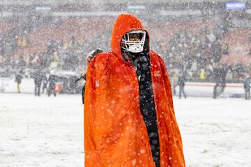 El jugador de los Cleveland Browns Jordan Akins (número 88) camina hacia los vestuarios arropado por una gabardina deportiva para protegerse del frío.