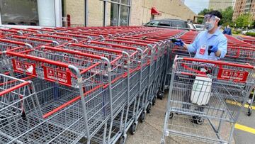 Empleado de Costco sanitizando los carritos del supermercado.