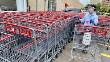 Empleado de Costco sanitizando los carritos del supermercado.