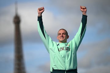 Kristof Rasovszky alza los brazos ante la sombra de la Torre Eiffel.