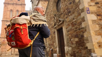 A shell, symbolizing the Camino de Santiago, hangs from the backpack of pilgrim Patrice Leprettre, 75, from France, as he visits Astorga, as wildfires spread to Picos de Europa mountains, Spain, August 18, 2025. REUTERS/Nacho Doce
