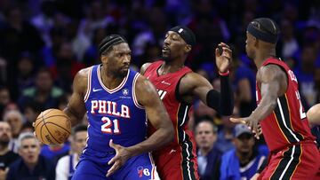 Joel Embiid #21 of the Philadelphia 76ers is guarded by Bam Adebayo #13 of the Miami Heat.