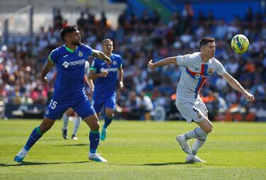 El jugador del Getafe, Alderete, observa como el jugador del Barcelona, Lewandowski se lleva el balón. 
 