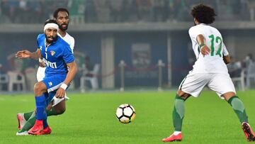 Saudi's Naif Hazazi (L) passes the ball to teammate Abdulrahman Obeid (R) as Kuwait's Fahad al-Enezi (C) defends during the 2017 Gulf Cup of Nations football match between Kuwait and Saudi Arabia at the Sheikh Jaber al-Ahmad Stadium in Kuwait Ci