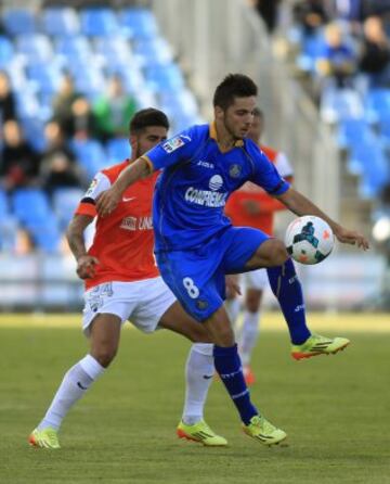 El centrocampista del Getafe Pablo Sarabia controla el balón ante un rival del Málaga, en partido de la trigésima quinta jornada de liga en Primera División que se disputa esta tarde en el Coliseo Alfonso Pérez. 