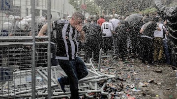 A man runs as Turkish anti-riot police use tear gas and water cannon to disperse supporters around the stadium before the Turkish Spor Toto Super league football match between Besiktas and Bursaspor at vodafone arena stadium on April 11, 2016