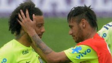 El delantero Neymar, del Barcelona, saluda al lateral izquierdo Marcelo, del Real Madrid, en el primer entrenamiento de Brasil para el Mundial 2014.