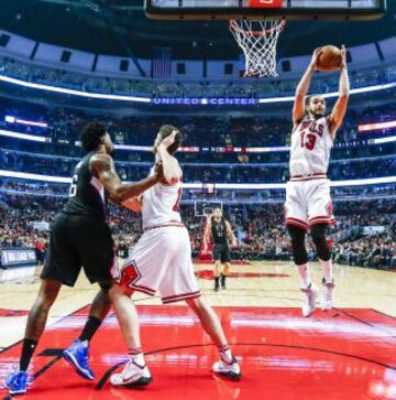 Joakim Noah atrapa un rebote mientras Pau Gasol bloquea a DeAndre Jordan.