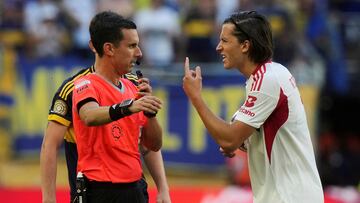 Benfica's Alvaro Carreras, right, pleads with referee CÈsar Arturo Ramos Palazuelos after he was giving yellow card during the Club World Cup group C soccer match between Boca Juniors and Benfica in Miami Gardens, Fla., Monday, June 16, 2025. (AP Photo/Marta Lavandier)