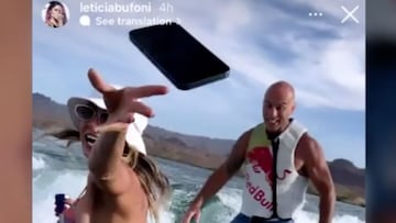 
 
 Leticia Bufoni tirando un tel&eacute;fono con una mano mientras con la otra agarra una lata de Red Bull, cayendo al agua frente a un wakesurfista con el chaleco de Red Bull y ba&ntilde;ador en un lago de los Estados Unidos, a principios de junio del 2